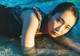 A woman laying on the beach in the water.