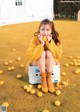 A woman sitting on top of a box of lemons.