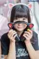 A young woman wearing a pair of cat ears headphones.