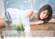 A woman laying on the floor next to a fish tank.