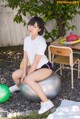 A woman sitting on an exercise ball in a backyard.