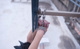 A person holding a pair of handcuffs on a railing.