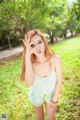 A young woman posing for a picture in a park.