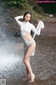 A woman in a white dress standing in the water.