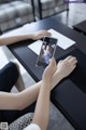 A woman sitting at a table with a cell phone in her hand.