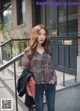 A woman standing on the steps of a building holding a red purse.