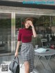 a woman in a red top and plaid skirt