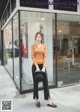 a woman standing in front of a store window