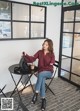 A woman sitting at a table with a cup of coffee.