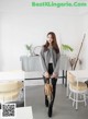 A woman standing in front of a white table and chairs.