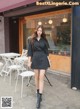 a woman in a black dress is walking down the street