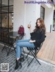 A woman sitting at a table with a cup of coffee.