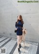 A woman in a blue dress is walking down the street.