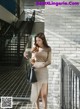 a woman in a beige skirt is walking down the stairs