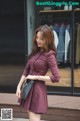 A woman in a purple dress is walking down the street.