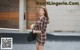 A woman in a plaid dress is walking down the street.