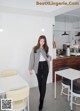 A woman walking through a white room with tables and chairs.