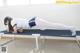 A woman doing a plank on a cot in a room.