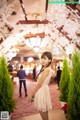 A woman in a white dress standing in a room.